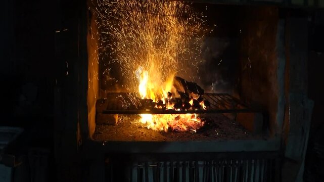 Preparing asado argentino Fireplace with burning logs