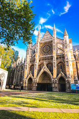 Obraz premium A detailed view of the magnificent Westminster Abbey in London, showcasing its intricate Gothic architecture surrounded by lush greenery. This historic landmark serves as a cultural and architectural 