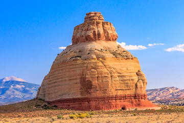 A large rock formation with a red and brown color