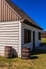 A white log cabin with a blue sky in the background