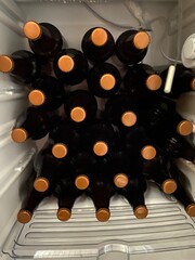 Craft beer bottles lined up with bronze-colored caps in the maturation process after bottling and fermentation. Made at home with a manual process enhancing different flavors and notes.