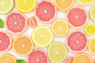 Fresh citrus slices arranged beautifully on clean surface, showcasing vibrant colors and textures. This delightful display includes lemons, limes, oranges, and grapefruits