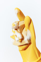Person in yellow rubber glove holding soap and another glove on white background