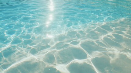 Fototapeta premium Crystal clear blue water with sunlight reflections in a serene pool setting