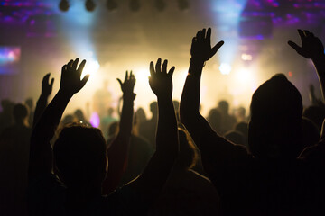 Silhouettes of People Worshipping with Raised Hands in a Concert or Worship Service