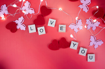 Red hearts and candles on red background with lighting love you letters word text 