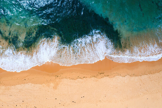 Ocean wave crashing at a sandy beach, aerial view, Sydney, Australia