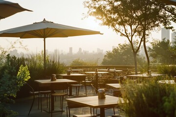 Rooftop restaurant terrace with empty tables overlooking cityscape at sunset
