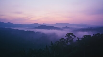 Obraz premium Serene mountain landscape at dawn with misty valleys and purple sky
