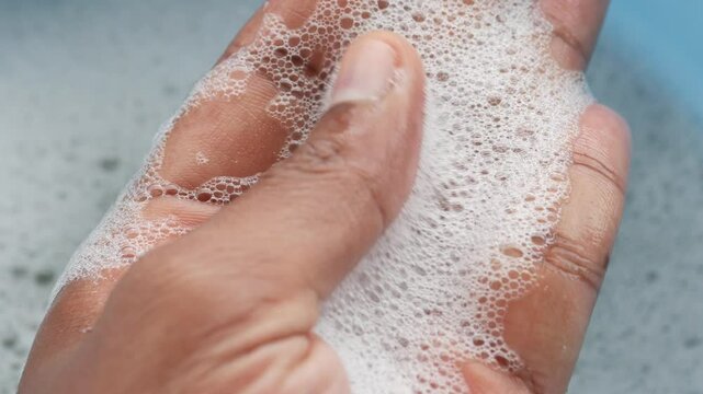 A detailed closeup view of soapy foam resting gently in a hand