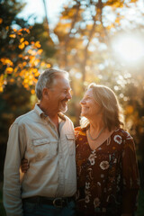 elderly man and woman smiling looking at each other standing outside in the park with nice sunny day