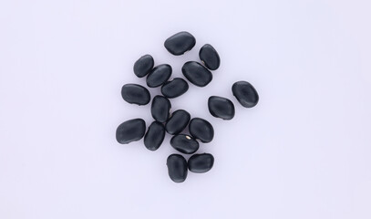 A pile of black beans flat lay on white background. Top view showing a pile of black beans in isolated on white background.