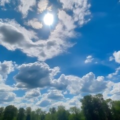 Bright Sun Shining Through Fluffy White Clouds Above Green Trees