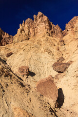 A rocky mountain with a blue sky in the background