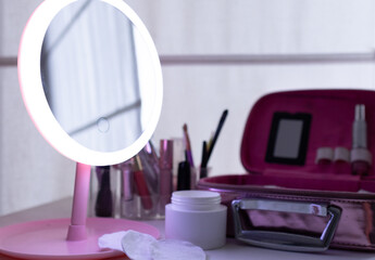 Naklejka premium Lighted foreground mirror, skin care products and cosmetics.