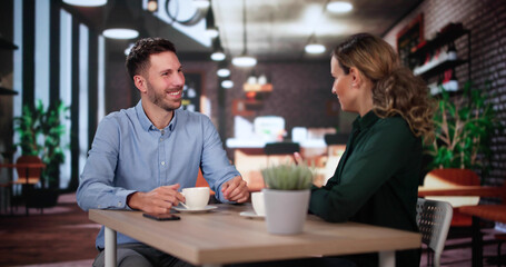 Laughing Male And Female Sitting In Cafe Drinking Coffee