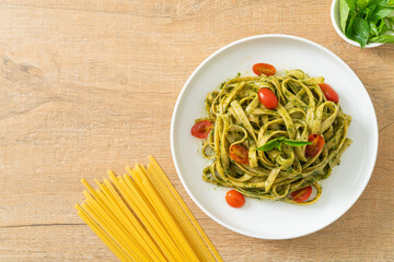 fettuccine spaghetti pasta with pesto sauce and tomatoes