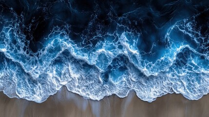Naklejka premium Aerial view of ocean waves crashing on sandy beach at night.