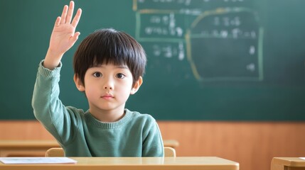 Young asian child in classroom raising hand to answer question