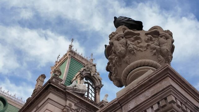 Vista parcial de un edificio antiguo a cielo despejado, palomas en la escena