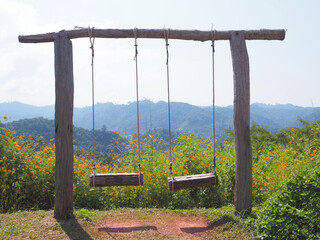 Wooden vintage swing over mountain background.