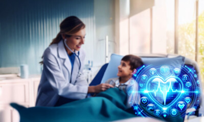 Obraz premium A smiling female doctor uses a stethoscope to examine a young boy lying in a hospital bed. The scene is bright and conveys a sense of care and comfort.