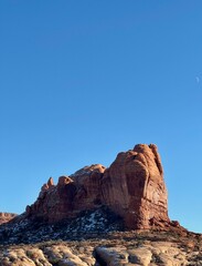 Red Rock Formation Against a Blue Sky with Crescent Moon