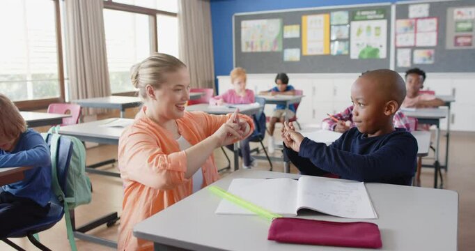 In school, female teacher helping student with math problems in classroom setting