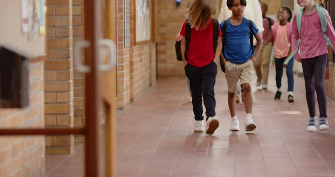 Walking in school hallway, children with backpacks heading to class