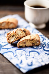 Cantuccini (Italian cookies) and a cup of coffee on dark wooden background. Close up.