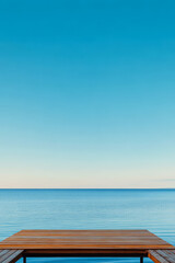 Fototapeta premium Vast blue horizon with calm waters and wooden deck under clear skies at sunset