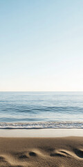 Fototapeta premium Serene ocean view with gentle waves on a sandy beach during a clear day at the coast