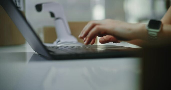 Close up of customer support specialist in logistics or post office worker processing online orders on laptop, working in warehouse retail center of postal service or E-commerce store. Slow motion. - Powered by Adobe