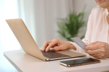 Senior Woman Holding Credit Cards and Paying Online with Laptop _ Digital-Friendly Senior