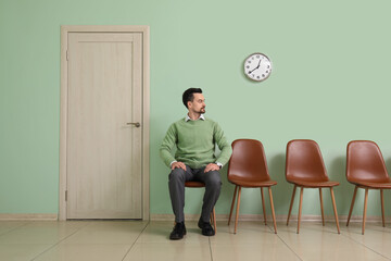 Young man waiting for job interview in room