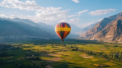 Fototapeta premium A colorful hot air balloon festival in a picturesque valley surrounded by mountains and open fields.