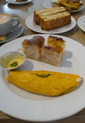 Tempting breakfast scene of a freshly made omelette served alongside crispy toast. Ideal for food...