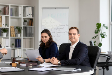 Male lawyer working with colleagues at table in office