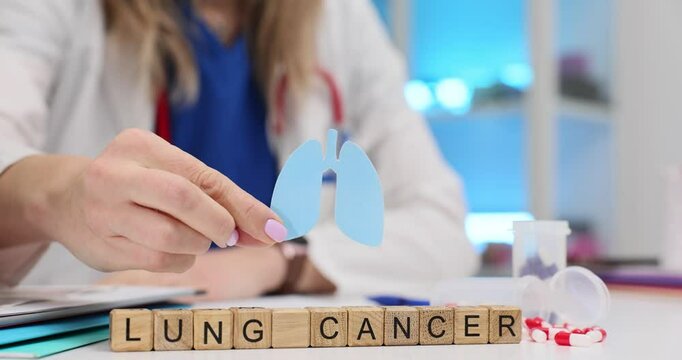 Phrase Lung Cancer of cubes and doctor showing paper breathing organs in clinic. Awareness about oncologic disease danger concept slow motion