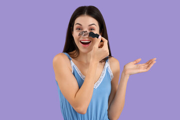 Young woman removing nose patch on lilac background