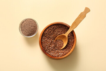 Bowls of flax seeds and flour on beige background