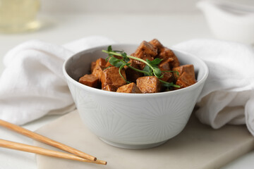 Bowl with pieces of fried tofu cheese and micro green on white background, closeup