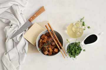Bowl with pieces of fried tofu cheese, thyme and micro green on white background