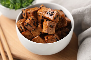 Bowl with pieces of fried tofu cheese on white background, closeup