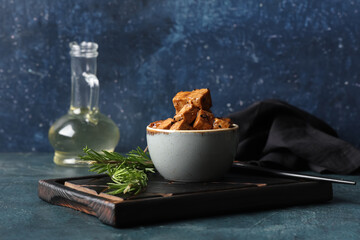 Bowl with pieces of fried tofu cheese and rosemary on dark background