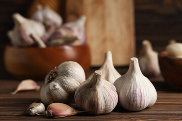 Many fresh garlic and cloves on wooden background