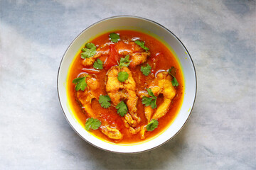 Fish curry in a bowl on a white table. Top view, flat lay
