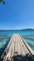 Obraz premium Serene Wooden Pier Extending Into Vibrant Blue Tropical Ocean