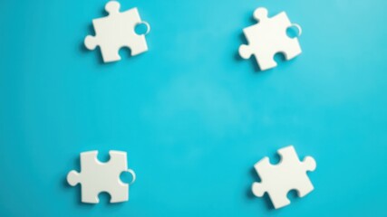 White puzzle pieces on a bright blue background, representing the concept of unity, connection, and problem-solving.