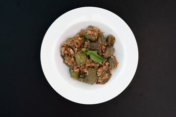 Stir-fried long eggplant (aubergine) with minced pork, on black white background. Top view.